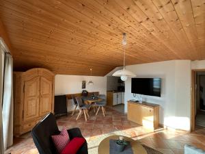 a living room with a wooden ceiling and a table at Landhaus Brigitte in Obermaiselstein