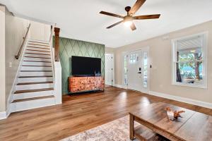 a living room with a ceiling fan and a tv at Welcome to Villa Rosa Farmhouse in Piedmont
