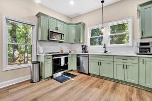 an empty kitchen with green cabinets and wooden floors at Welcome to Villa Rosa Farmhouse in Piedmont