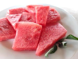 a pile of watermelon slices on a white plate at Campement Houefa in Ndangane