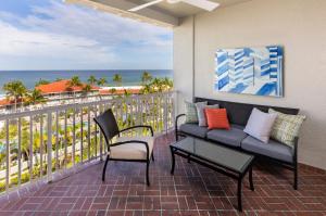 a balcony with a couch and chairs and the ocean at La Playa Beach & Golf Resort, a Noble House Resort in Naples