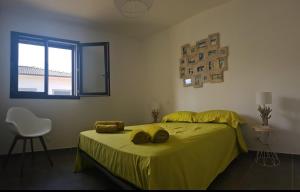 a bedroom with a bed with yellow sheets and a window at Villa Cosy avec piscine privative in Ghisonaccia +14 photos