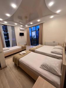 a hotel room with three beds and a television at G guesthouse in Kobuleti +52 photos