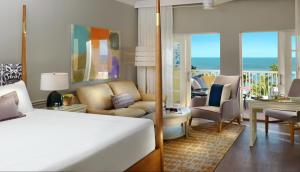 a bedroom with a bed and a living room at La Playa Beach & Golf Resort, a Noble House Resort in Naples