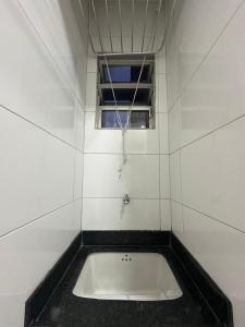 una bañera en una habitación con ventana en Studio a 400m da praia, en Guarapari