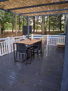 una mesa de madera y sillas en una terraza de madera en Camping Les Acacias, en Saint-Paulet-de-Caisson