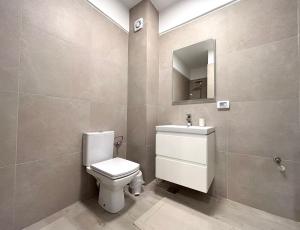un bagno con un water, un lavandino e uno specchio di MERAKI resort & spa a Mamaia Nord - Năvodari