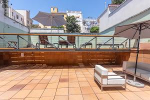 a patio with tables and chairs and an umbrella at My Space Emirates - Bright Apartment in Gracia with shared Pool in Barcelona +34 photos