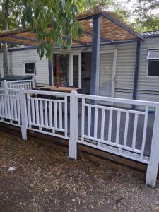 una cerca blanca frente a una casa en Camping Les Acacias, en Saint-Paulet-de-Caisson