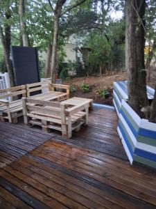 una terraza de madera con 2 bancos encima en Camping Les Acacias, en Saint-Paulet-de-Caisson 6 fotos más