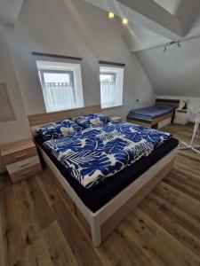 a bedroom with a bed with a blue and white comforter at Apartment in Gaspoltshofen