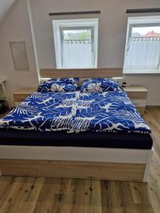 a bed with blue and white sheets and pillows at Apartment in Gaspoltshofen