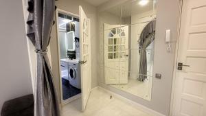 baño blanco con lavadora y puerta en Panoramic apartment on Hamid Alimjan square, en Salor Bekati