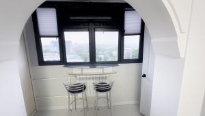 2 taburetes en una habitación con ventana en Panoramic apartment on Hamid Alimjan square, en Salor Bekati 8 fotos más