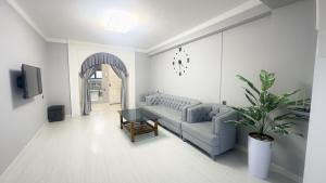 una sala de estar con un sofá y una mesa en Panoramic apartment on Hamid Alimjan square, en Salor Bekati