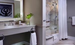 a bathroom with a sink and a shower at La Playa Beach & Golf Resort, a Noble House Resort in Naples