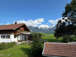 a house with snow covered mountains in the background at Landhaus Brigitte in Obermaiselstein