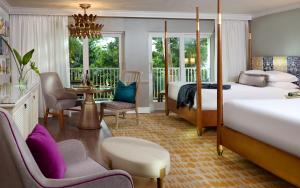 a hotel room with two beds and a table and chairs at La Playa Beach & Golf Resort, a Noble House Resort in Naples