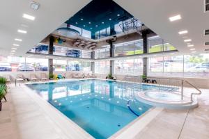 a large swimming pool in a large building at Resort Apartamenty Klifowa Rewal 97 in Rewal
