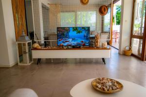 a living room with a large tv and a table at Milies Apartments in Stavros +121 photos