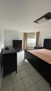 Un dormitorio con una cama y un escritorio y una ventana. en Mikano Properties, en Jayuya