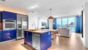 a kitchen with blue cabinets and a table in it at Exclusive Beachfront Condo at W Fort Lauderdale in Fort Lauderdale