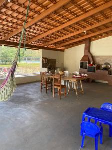 a room with a table and chairs and a hammock at Rancho Royer in Araguari