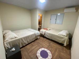 a room with two beds and a table in it at Rancho Royer in Araguari