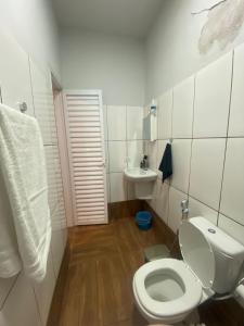 a white bathroom with a toilet and a sink at Rancho Royer in Araguari +14 photos