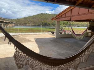 a hammock outside a building with a view of a field at Rancho Royer in Araguari