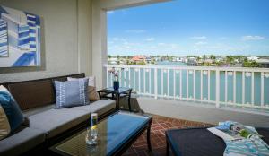 a living room with a couch and a balcony at La Playa Beach & Golf Resort, a Noble House Resort in Naples