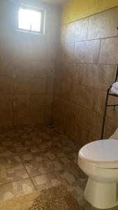 a bathroom with a toilet and a window at La Reina del Mar in Drake