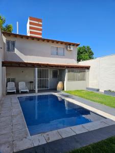 a swimming pool in front of a house at Lamadrid Lodge in Mendoza