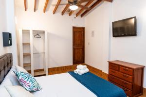 a bedroom with a bed and a tv and a couch at Costa Beach in Zorritos