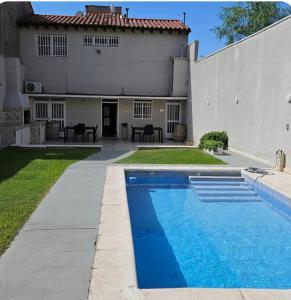a swimming pool in front of a house at Lamadrid Lodge in Mendoza