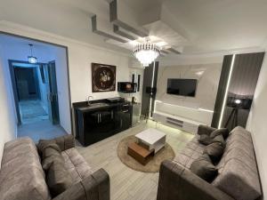 a living room with a couch and a television at Pyramids Elsewedy home in Ghaţāţī