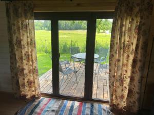a view of a patio with a table and chairs through a window at Domek pod jesionami in Ruciane-Nida