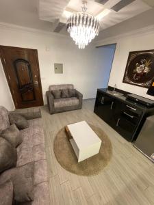 a living room with a couch and a table at Pyramids Elsewedy home in Ghaţāţī +10 photos