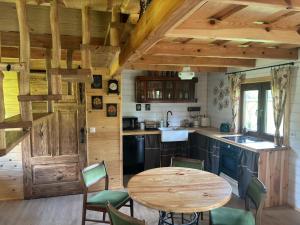 a kitchen with a wooden table and a wooden door at Domek pod jesionami in Ruciane-Nida