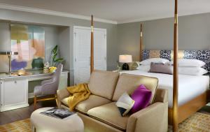 a hotel room with a bed and a couch at La Playa Beach & Golf Resort, a Noble House Resort in Naples