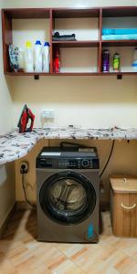 a washing machine in a room with a counter at Luxe Living in Kampala