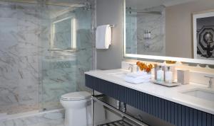a bathroom with a toilet and a sink and a shower at La Playa Beach & Golf Resort, a Noble House Resort in Naples