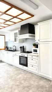 a kitchen with white cabinets and a stove top oven at La Verrière d'Opale - Maison proche plage et CNPE EDF in Grand-Fort-Philippe +30 photos