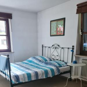 a bedroom with a bed with a blue and white comforter at Ferienwohnung Am Kurpark in Aschau im Chiemgau