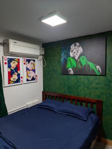 チェンナイにあるCarbon Stays - Couples & Travelers Friendly Stayの緑の壁のベッドルーム1室(青いベッド1台付)