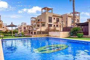 a large swimming pool in front of a house at Oasis in Los Collados - 2BR - Pool & Garden in Águilas