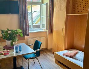 图尔恩Junges Hotel Tulln - NÖ Jugendherbergswerk的小房间设有桌椅和窗户