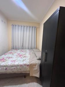 a small bedroom with a bed and a window at Furnished house in Fazenda Rio Grande