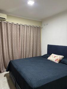 a bedroom with a blue bed with a pillow on it at Furnished house in Fazenda Rio Grande +4 photos