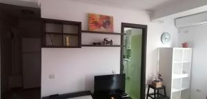 Ein Wohnzimmer mit einem Fernseher an einer weißen Wand in der Unterkunft Dancing soul studio in Bukarest